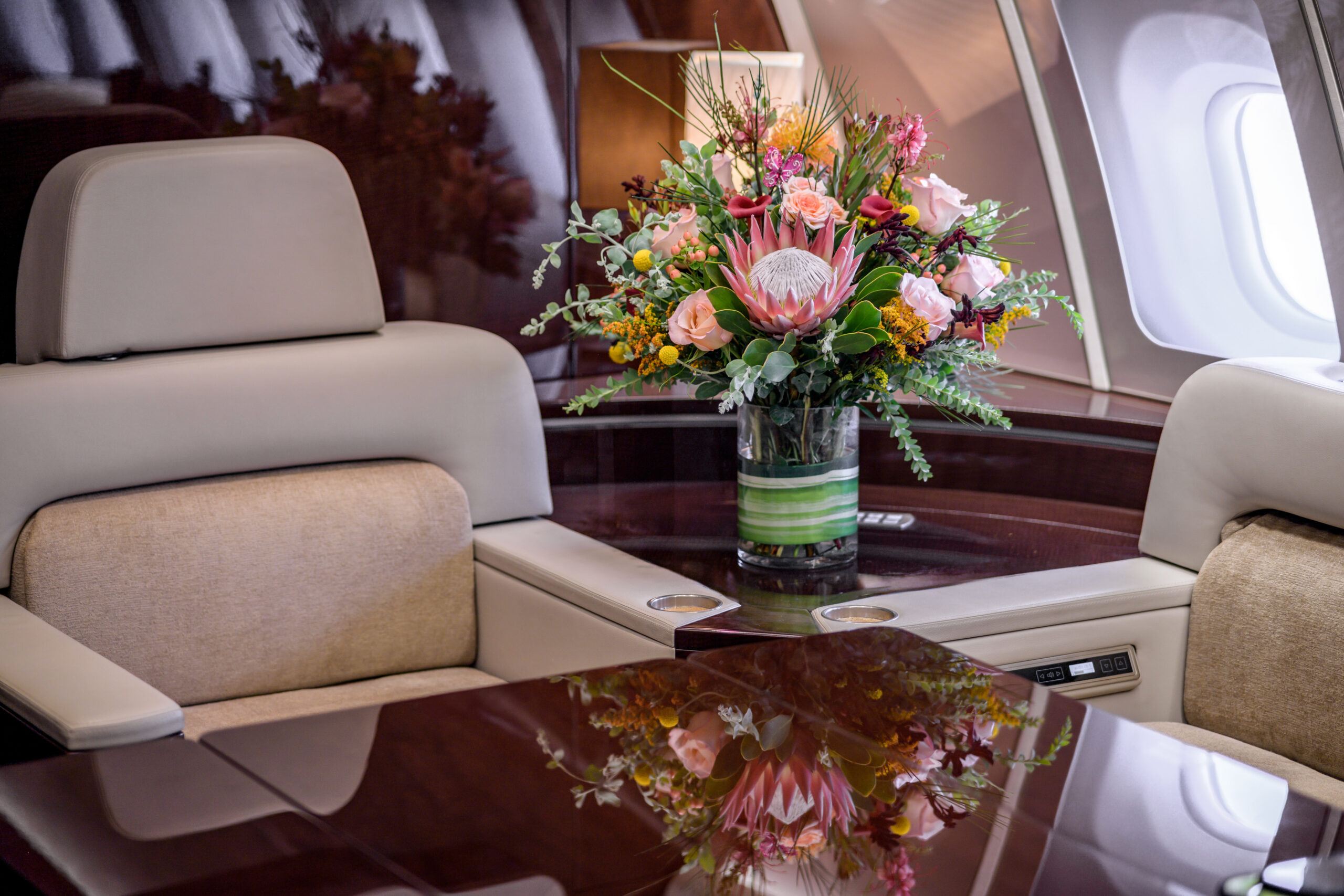 Floral centerpiece and refined lighting in a VVIP jet cabin — professional staging and jet interior photography that elevates.
