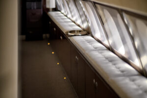 Luxury bench seating and cabinetry detail aboard a VVIP bizliner aircraft — refined private jet interior.