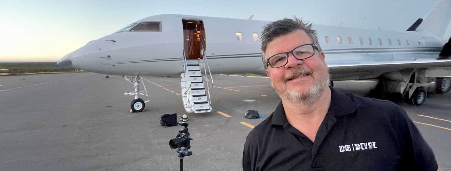Dave Koch working on the ramp at South Lake Tahoe Airport with camera gear positioned in front of a private jet during an exterior aviation photoshoot.