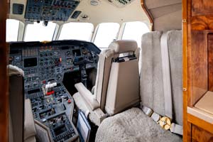 Business jet cockpit interior photographed by AeroMedia on the ramp at London Luton Airport, featuring dual pilot seats and advanced avionics suite.