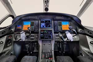 Modern business jet cockpit photographed by AeroMedia inside a private hangar at London Luton Airport, featuring dual pilot seats and advanced avionics displays