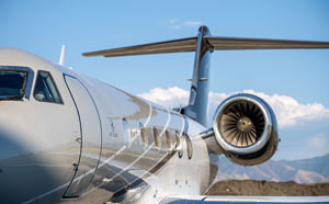 Private jet exterior photographed in the Caribbean with polished fuselage reflections and a detailed turbine engine view.