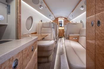 Gulfstream G150 cabin interior with luxury seating and wood cabinetry photographed at Bozeman Yellowstone International Airport.
