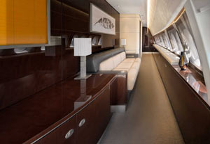 Luxurious private jet interior with cream leather seating and dining table, photographed at Hong Kong International Airport