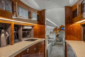 Luxury business jet interior showing galley and main cabin seating, photographed by AeroMedia inside a private hangar at London Biggin Hill Airport, United Kingdom