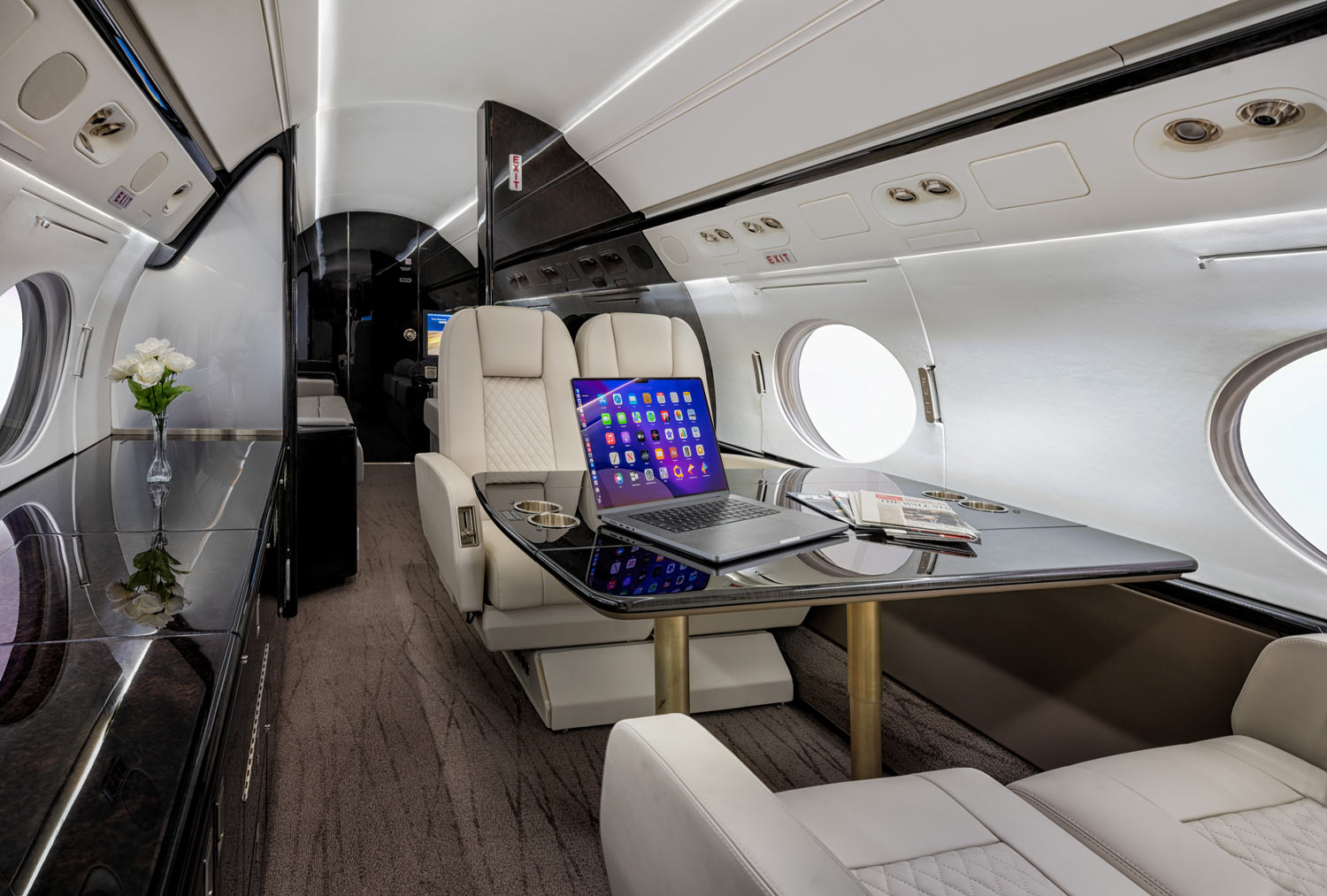 Executive jet cabin photographed in Osaka with white leather seating and onboard workspace at Kansai Airport