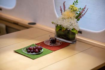 Private jet cabin table detail with espresso and service setup photographed in Chicago