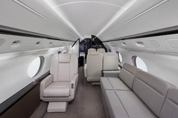 Luxury private jet cabin with cream leather seat and light-gray divan, photographed at Palm Beach International Airport in West Palm Beach. Aircraft Photographer in West Palm Beach