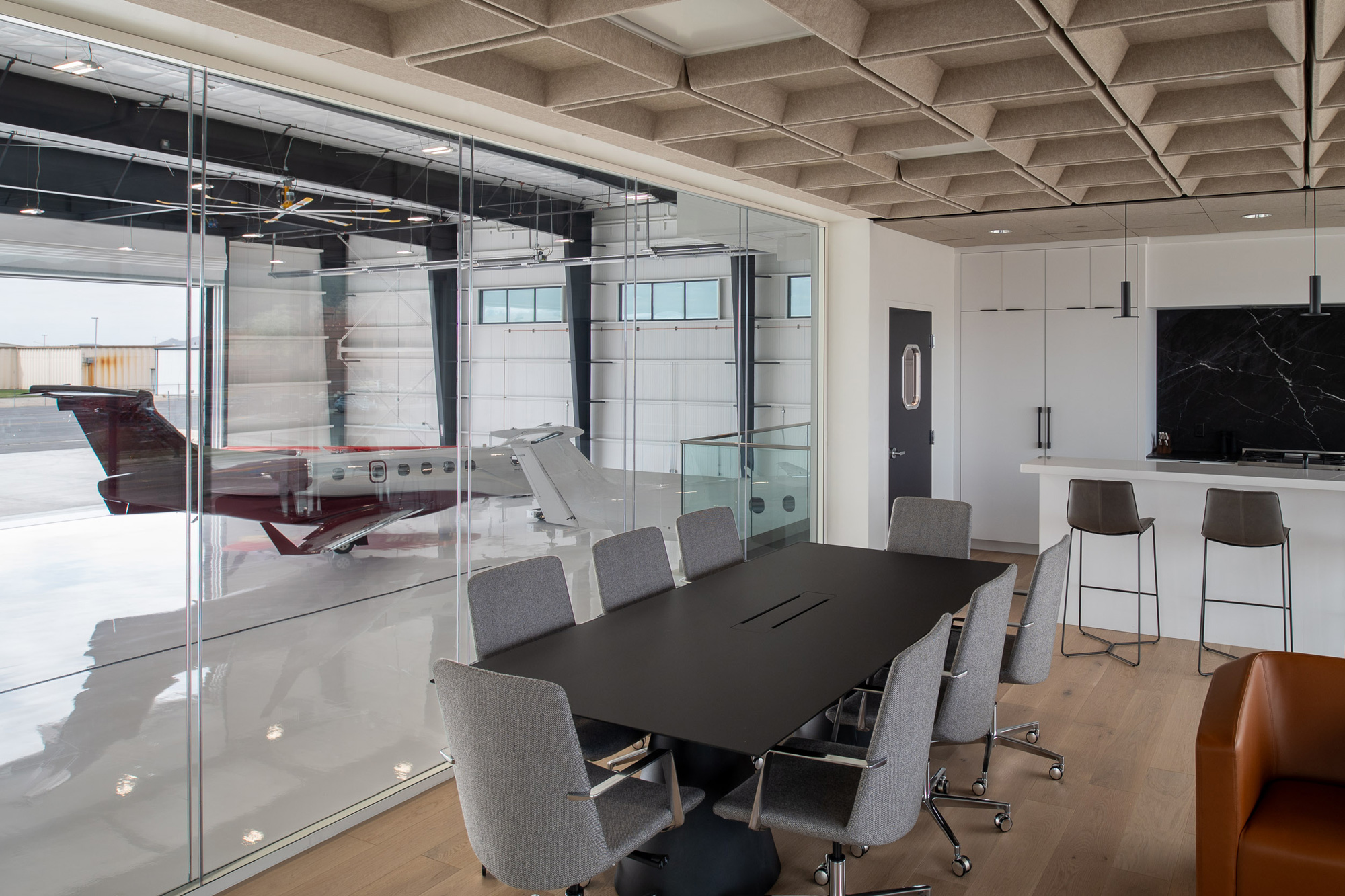 Interior office space in Teterboro overlooking a hangar with a maroon Pilatus PC-24