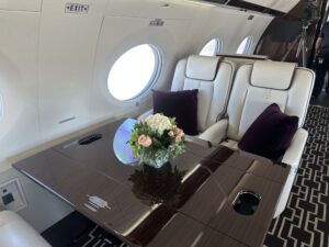 Interior of Gulfstream G650 with fresh floral centerpiece on the table, showcasing staged luxury environment for charter marketing.